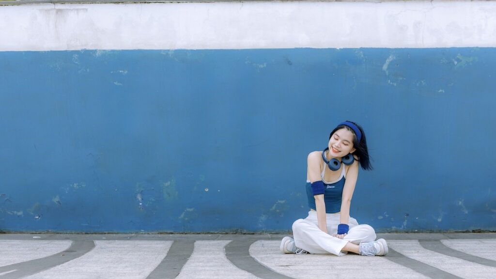 青い壁と笑顔で座っている女性