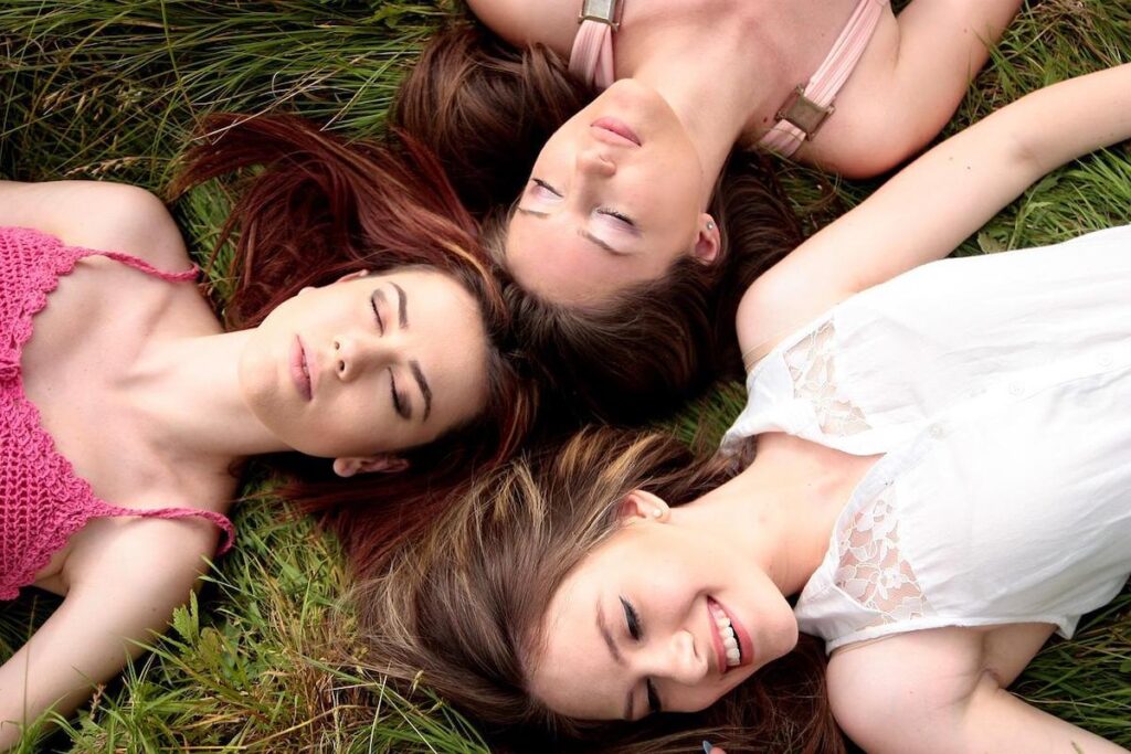 芝生で横になってリラックスしている3人の女性