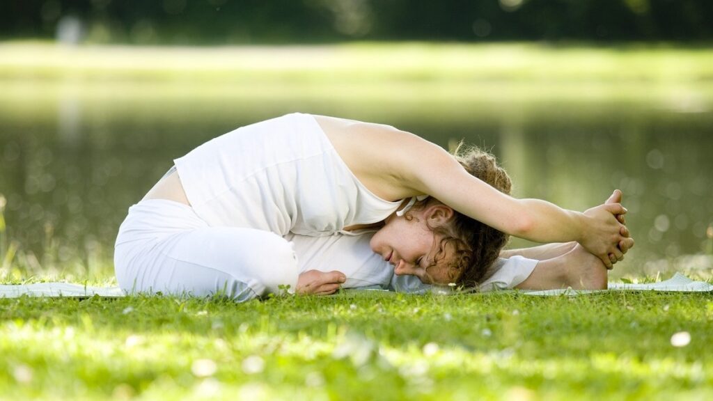 芝生の上でヨガをしている女性